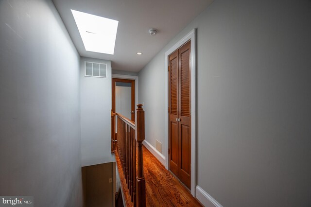 corridor featuring a skylight and dark wood-type flooring