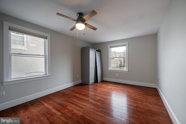 unfurnished bedroom featuring ceiling fan and dark hardwood / wood-style flooring