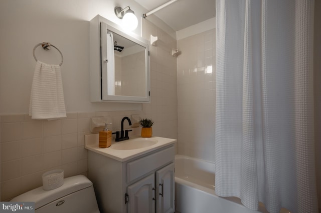 full bathroom with vanity, shower / tub combo, tile walls, and toilet