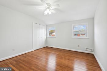 unfurnished bedroom featuring multiple windows, ceiling fan, and hardwood / wood-style floors