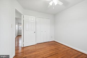 unfurnished bedroom with hardwood / wood-style floors, ceiling fan, and a closet