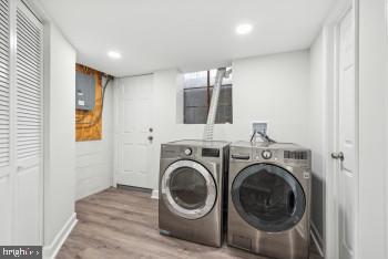 laundry area with washer and dryer and light hardwood / wood-style floors