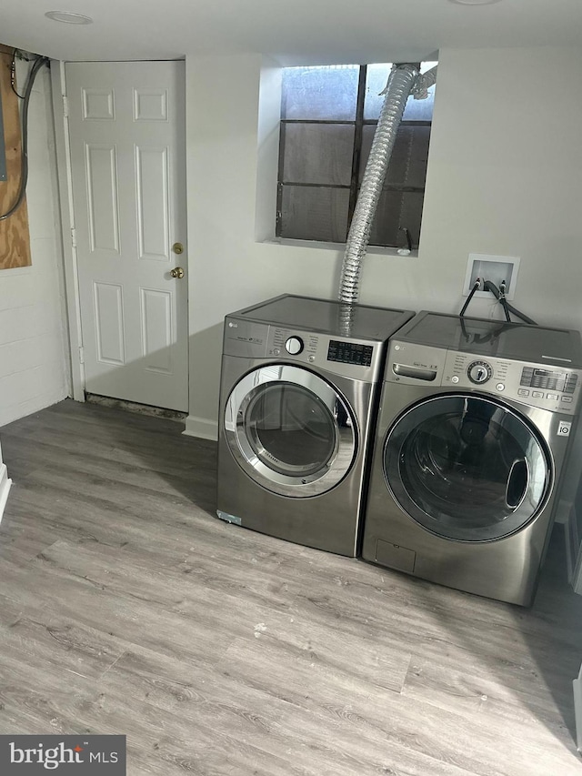 laundry area with light wood-type flooring and washing machine and dryer