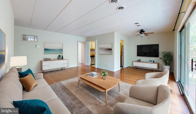 living room with ceiling fan and light hardwood / wood-style floors