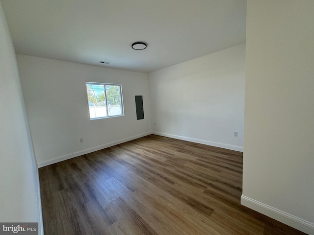 unfurnished room with dark wood-type flooring and electric panel