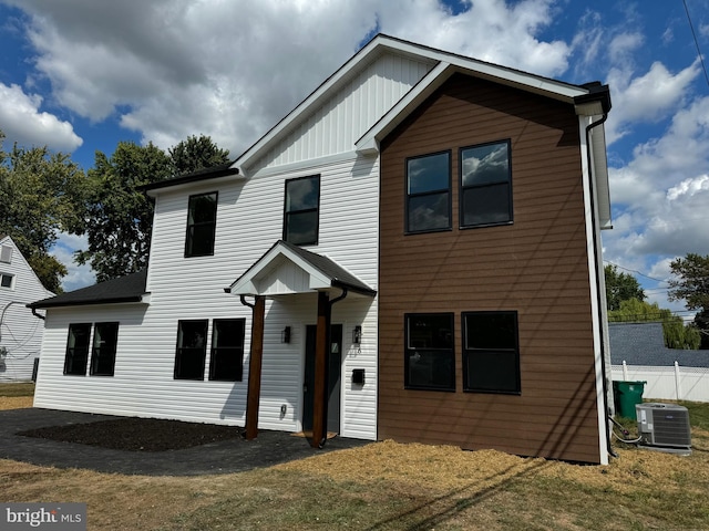 view of front facade featuring central air condition unit and a front yard