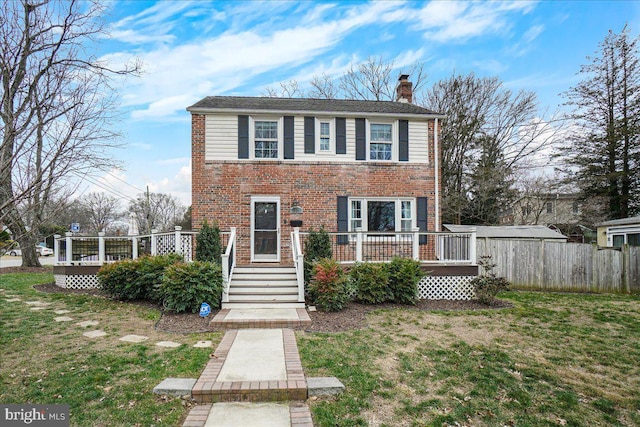 view of front of house featuring a front lawn and a deck