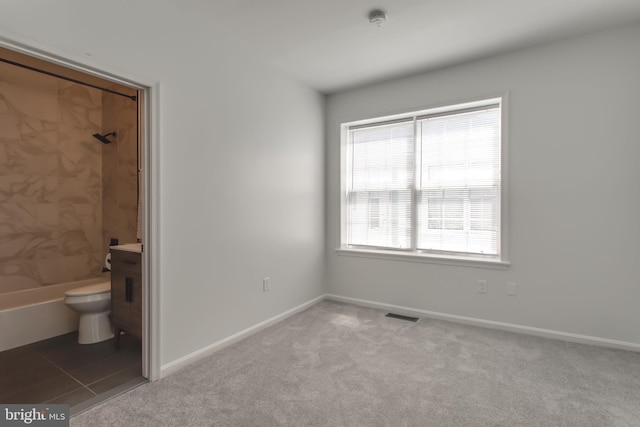 unfurnished bedroom with light colored carpet and ensuite bath