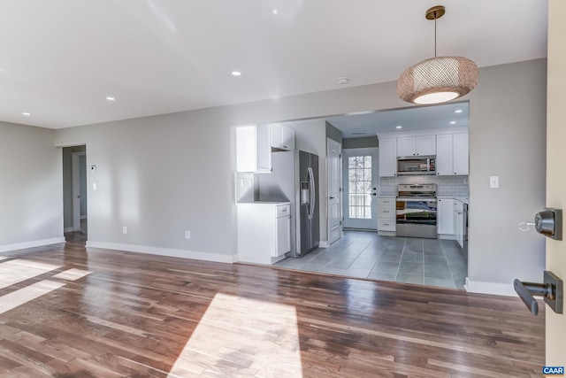 kitchen featuring white cabinetry, stainless steel appliances, backsplash, and dark hardwood / wood-style flooring