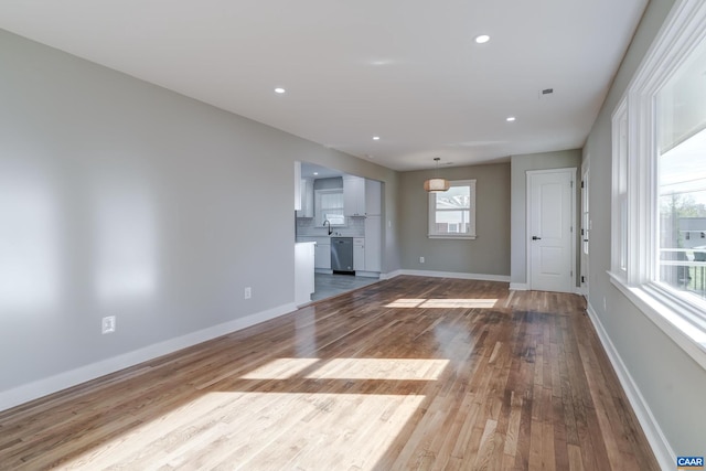 unfurnished living room featuring light wood-type flooring and sink