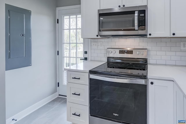 kitchen featuring white cabinetry, electric panel, appliances with stainless steel finishes, and backsplash