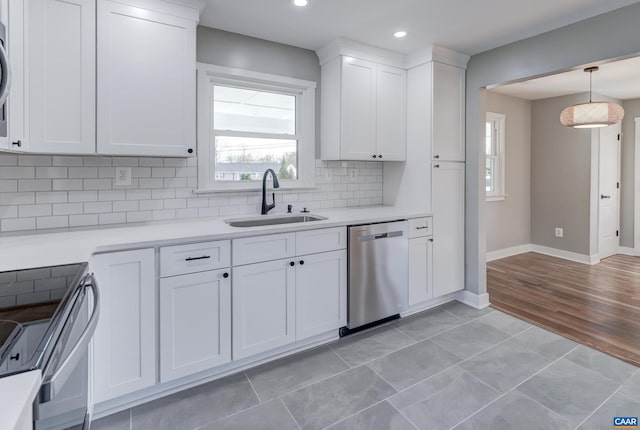 kitchen with white cabinets, sink, light wood-type flooring, and appliances with stainless steel finishes