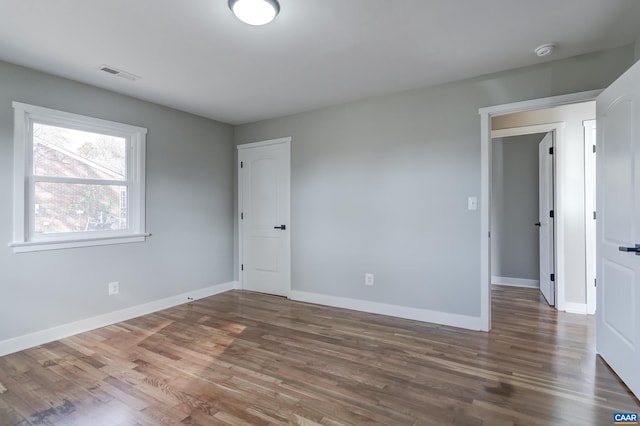 unfurnished room with dark hardwood / wood-style flooring