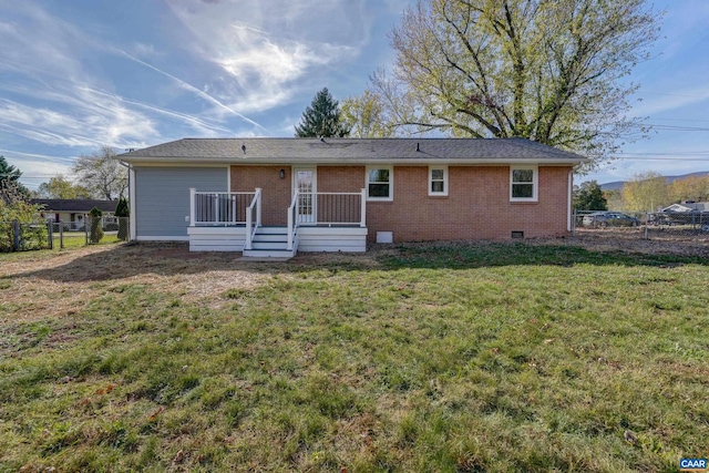 rear view of house with a yard and a deck