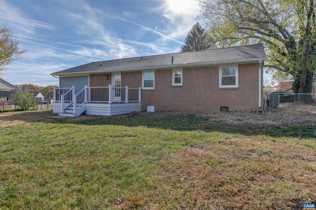 rear view of property with a lawn and a wooden deck