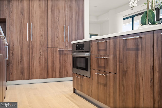 kitchen featuring stainless steel oven and light hardwood / wood-style flooring