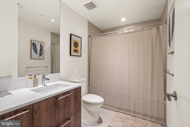 bathroom featuring vanity, toilet, and tile patterned flooring