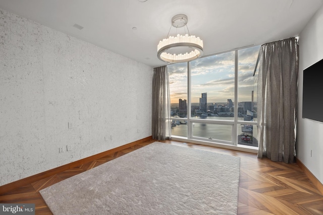 unfurnished room with a notable chandelier and parquet flooring