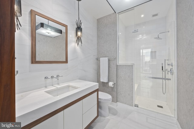 bathroom featuring a shower with door, vanity, tile walls, and toilet