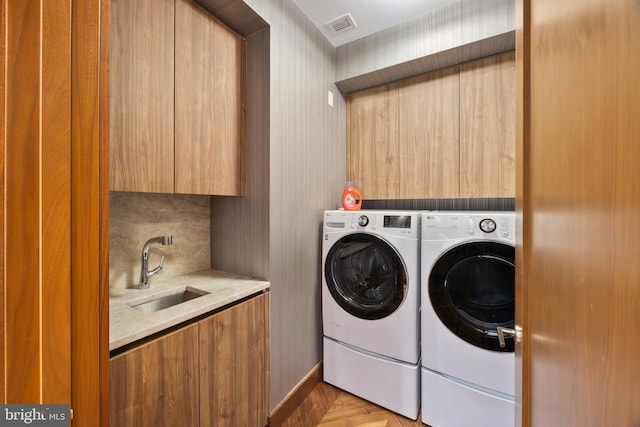 washroom featuring washer and clothes dryer, cabinets, and sink