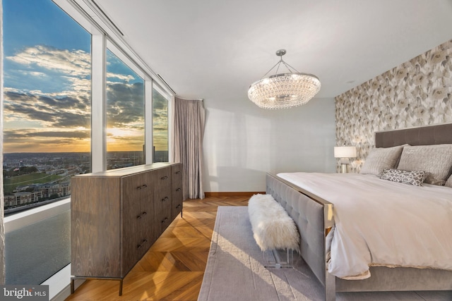 bedroom with light parquet flooring and an inviting chandelier