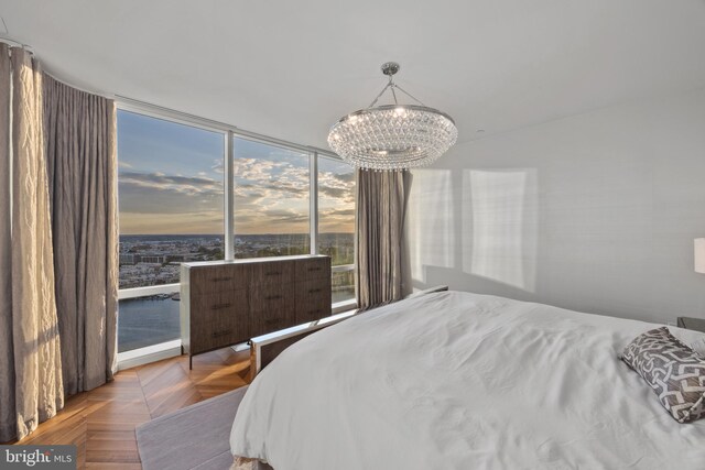 bedroom featuring parquet flooring and a chandelier