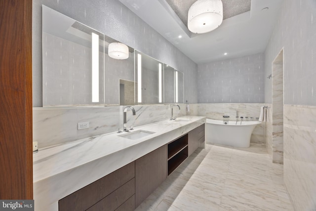 bathroom featuring a bathtub, vanity, and tile walls