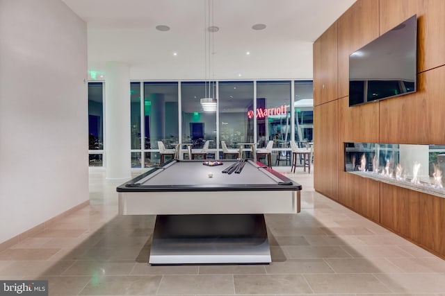 playroom with a wall of windows, light tile patterned floors, and pool table