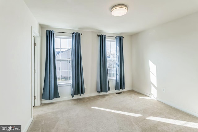 spare room featuring light colored carpet