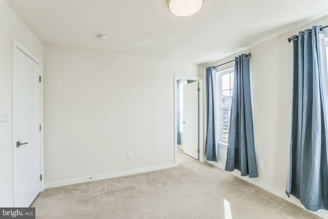 unfurnished bedroom featuring light carpet