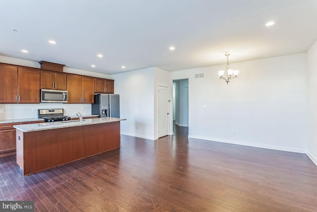 kitchen with stainless steel appliances, dark hardwood / wood-style flooring, backsplash, pendant lighting, and a center island with sink