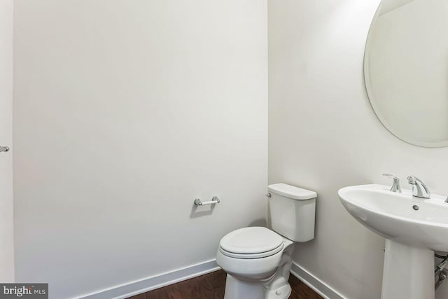 bathroom featuring sink, hardwood / wood-style floors, and toilet