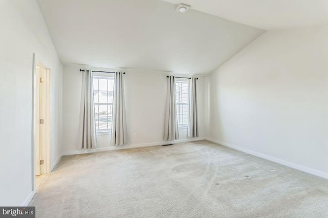 empty room with light carpet and lofted ceiling