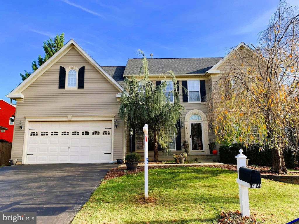 view of property with a garage and a front lawn