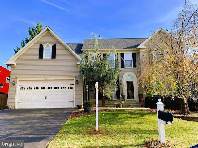 view of property with a garage and a front lawn