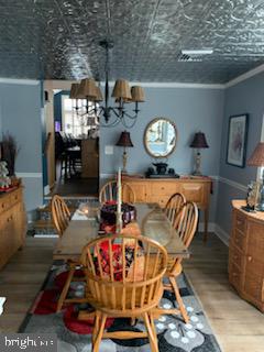 dining room with crown molding, wood-type flooring, and a textured ceiling