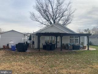 rear view of house with a gazebo, an outdoor hangout area, and a yard