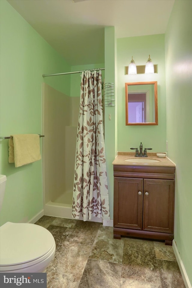 bathroom with curtained shower, vanity, and toilet