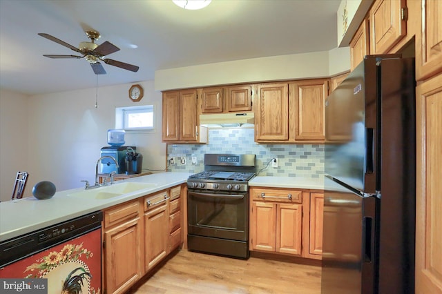 kitchen featuring sink, dishwashing machine, gas stove, light hardwood / wood-style floors, and stainless steel refrigerator