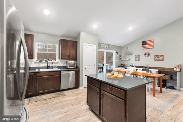 kitchen with sink, tasteful backsplash, light hardwood / wood-style flooring, lofted ceiling, and appliances with stainless steel finishes