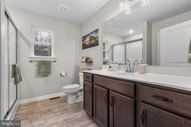 bathroom with vanity, wood-type flooring, a shower with shower door, and toilet