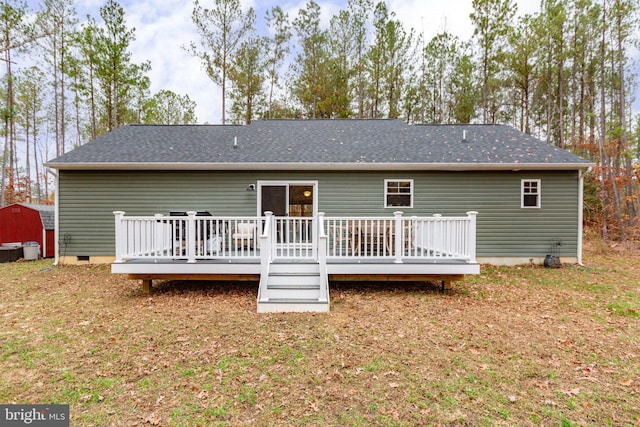 back of house with a shed and a deck