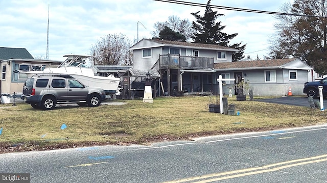 view of front of home with a balcony and a front lawn