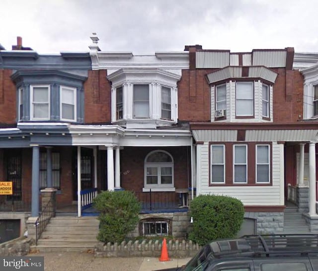 townhome / multi-family property featuring covered porch