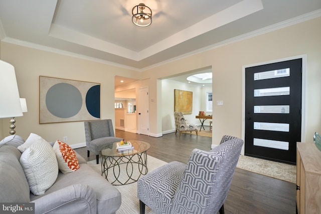 living room featuring crown molding, dark hardwood / wood-style floors, and a raised ceiling