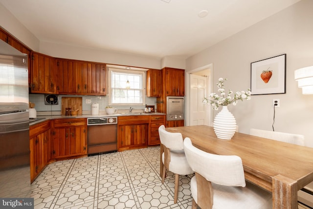 kitchen with stainless steel refrigerator, dishwasher, sink, and backsplash