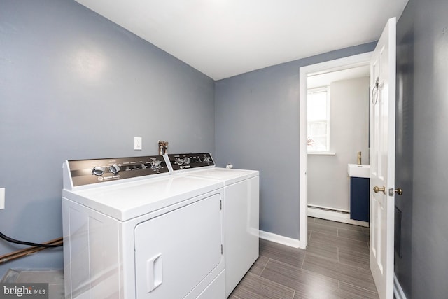 washroom featuring washing machine and dryer and a baseboard heating unit