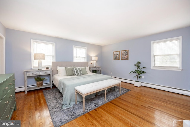 bedroom featuring hardwood / wood-style flooring and a baseboard radiator