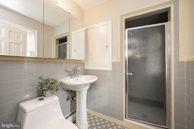 bathroom featuring sink, tile walls, backsplash, an enclosed shower, and toilet