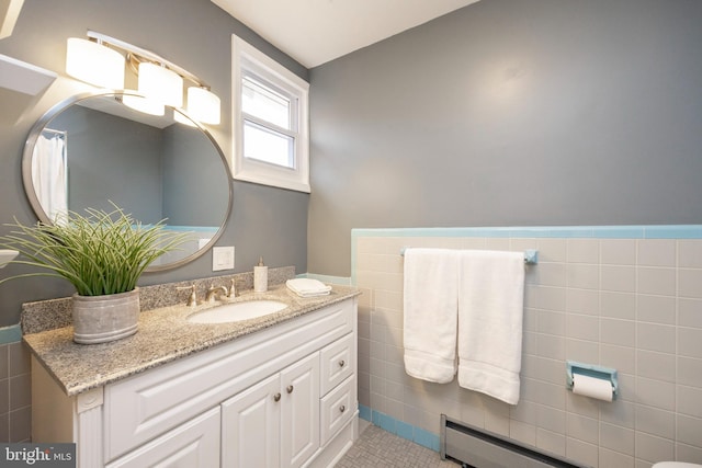 bathroom featuring a baseboard radiator, vanity, tile patterned flooring, and tile walls